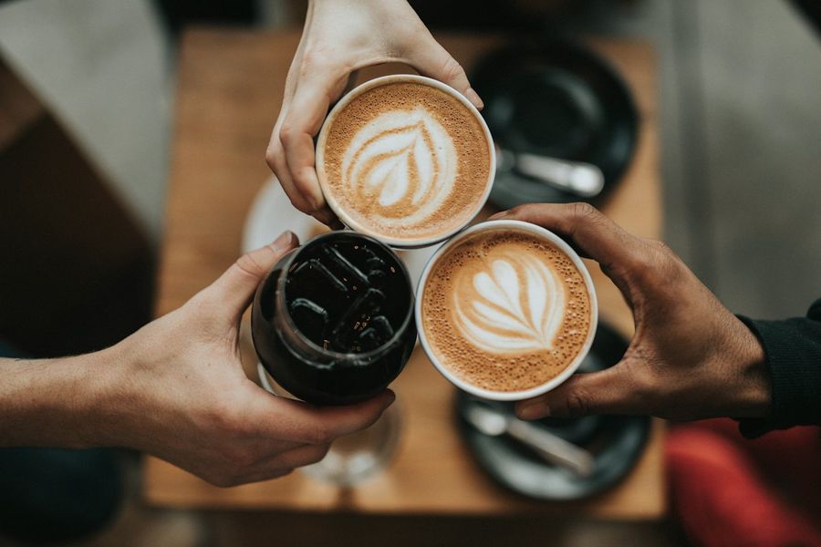 Two hands toasting with lattes